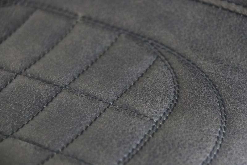 Detail van luxe stikwerk en premium leder op een handgemaakt café racer motorzadel voor Honda CB750 van Atelier Vertez